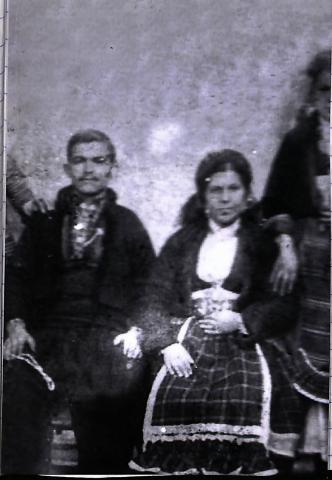 Οικογενειακή φωτογραφία,κατά την δεκαετία του 1930.Στην φωτογραφία διακρίνονται ένας άντρας και μια γυναίκα καθιστοί. Είναι ντυμένοι με την παραδοσίακη ενδυμασία. Ασπρόμαυρη φωτογραφία.