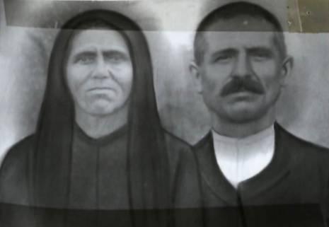 Εικόνα που απεικονίζει μία γυναίκα και έναν άντρα. Η γυναίκα φοράει μαντήλι στο κεφάλι. Ο άντρας είναι κοντοκουρεμένος με μουστάκι.